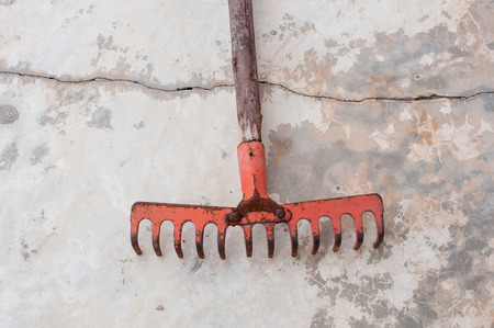 red old rake on the break cement floor groundの写真素材