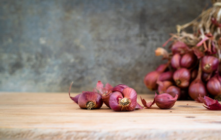 Shallots on old wooden table with shallots bunch background