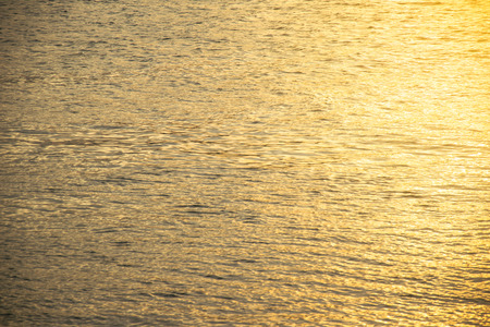 blurred of Golden rippled water surface an the sunrise or sunset.の写真素材