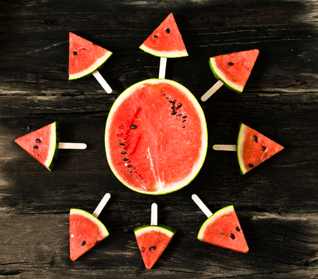 watermelon slice popsicles on a rustic wood backgroundの写真素材