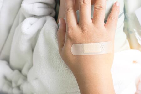 plaster close wound on back hand on the bed in hospital