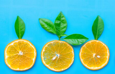 Summer of slice orange fruit with green Leaves on blue backgroundの写真素材