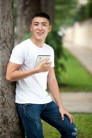 Asian handsome student boy with tabletの写真素材