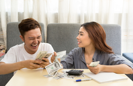 Asian young couple happy with moneyの写真素材