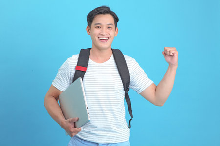 Asian handsome and cheerful young student man, isolated on backgroundの写真素材