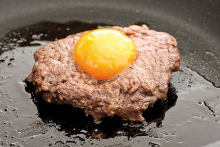 Meat ball with yolk on top, fryingの写真素材