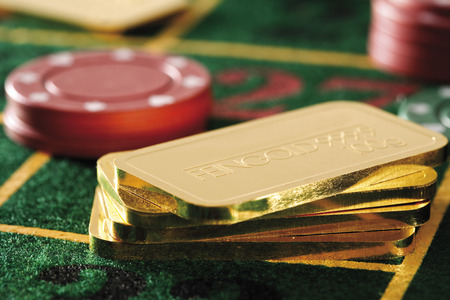 Gambling chips and gold bars on roulette tableの写真素材