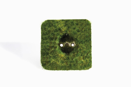 Plug socket with grass against white backgroundの写真素材