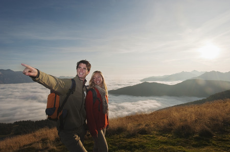 Austria, Steiermark, Reiteralm, Hikers in mountains, man pointing, smiling, portraitの写真素材