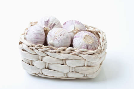 Chinese garlic bulbs in basket on white backgroundの写真素材