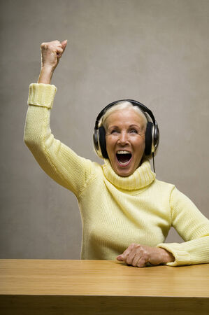 Senior woman wearing headphones, laughingの写真素材