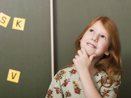 Girl standing in front of blackboardの写真素材