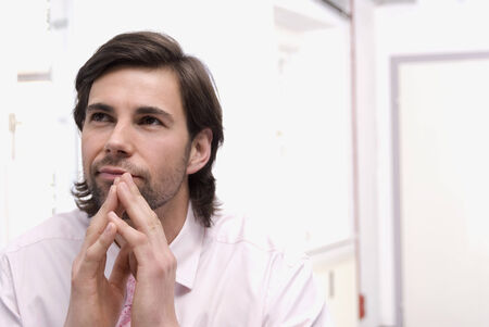 Young man sitting in office looking upの写真素材