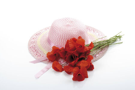 Light pink girlish summer hat and a bunch of poppiesの写真素材