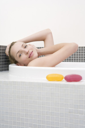 Young woman taking bath, side view, portraitの写真素材