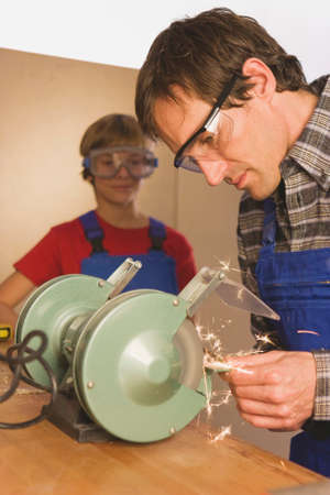 Father and son working on grinding machine