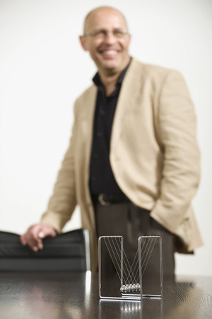 Germany, Munich, Businessman in office, Ball pendulum in foregroundの写真素材