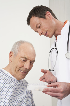 Doctor showing pills to patientの写真素材