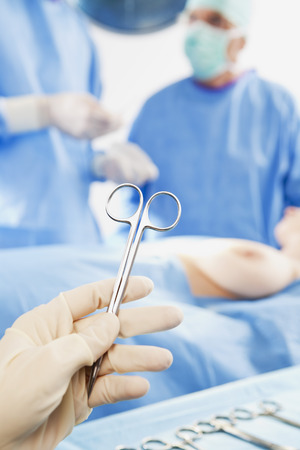 Two surgeons preparing to operate on breastの写真素材