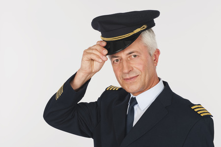 Close up of senior flight captain saluting on white background