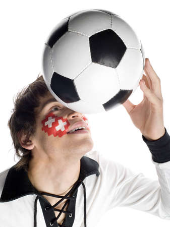 Man with Swiss flag painted on face and playing with footballの写真素材