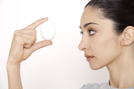 Young woman holding egg, portrait