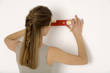 Young woman holding red spirit level, close-upの写真素材