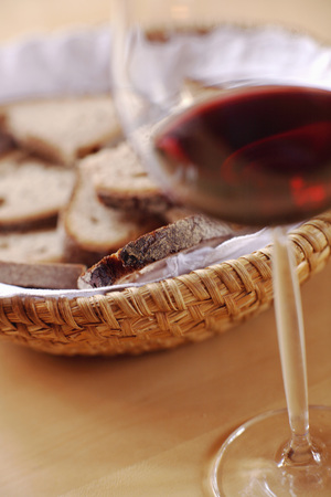 Bread basket and glass of wineの写真素材