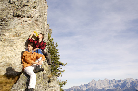 Young couple relaxing on mountain peakの写真素材