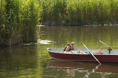 Italy, South Tyrol, Young couple lying in rowing boatの写真素材