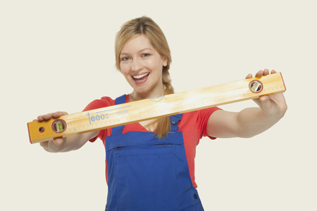 Young woman holding spirit level smiling