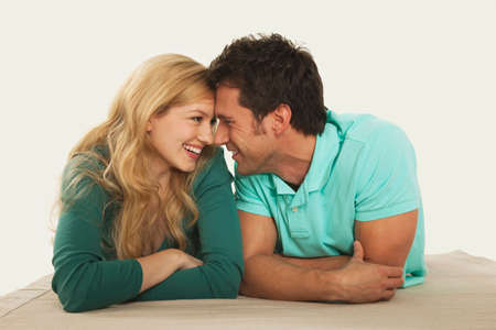 Couple lying on floor rubbing noses smiling