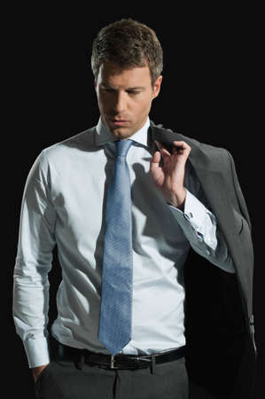 Businessman with jacket over shoulder thinkingの写真素材