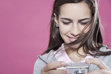 Adorable teenage girl looking at digital camera smiling close upの写真素材