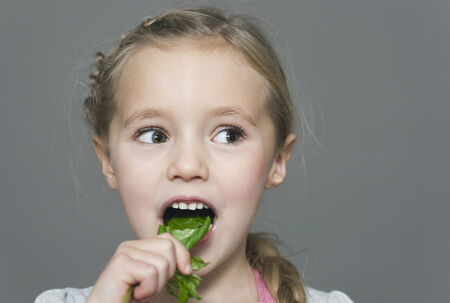 Blonde girl eating lettuce leafの写真素材