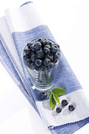Blueberries in glass on place matの写真素材