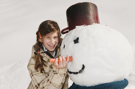 Austria, Salzburger Land, Altenmarkt, Girl and snowman, portraitの写真素材