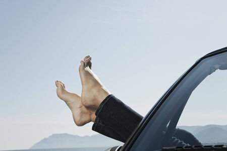 Spain, Mallorca, Young woman's feet out of carの写真素材
