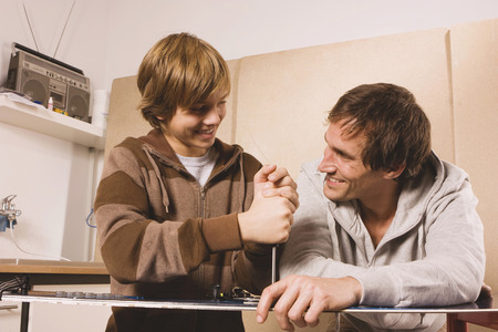 Father and son fixing snowboardの写真素材