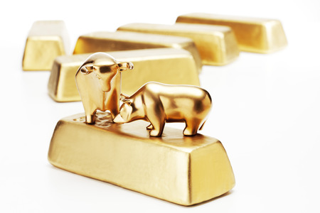 Golden bull bear figurine on gold barsの写真素材