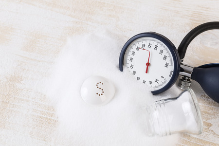 Salt consuming can increase blood pressure, pile of salt, blood pressure gauge on ecg recordの写真素材