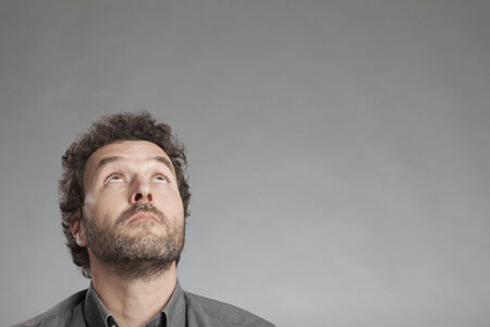 Man in grey shirt looking up