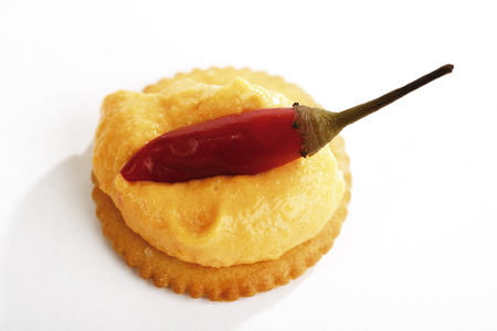 Crackers with cheese cream, garnished with red pepperonisの写真素材