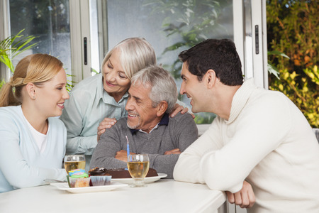 Couple with parents eating cake in kitchen