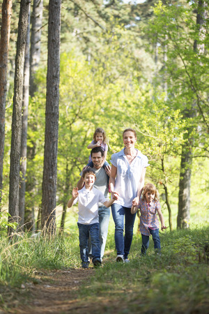 happy family taking a walk in forestの写真素材