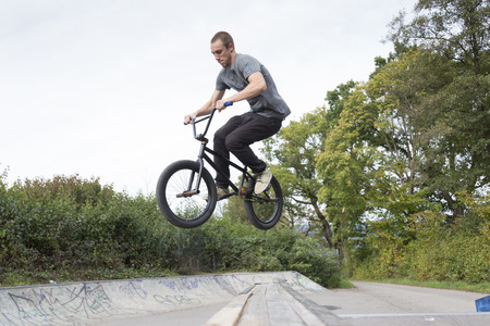 Young man jumping on bike ramp