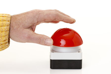 Hand pressing red game show buzzerの写真素材