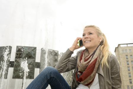 Young woman using smart phone, Germany, Berlin, Strausberger Platzの写真素材