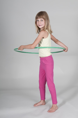 Blonde girl exercising hoola hoopの写真素材