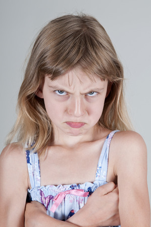 Little blonde girl looking angy, arms crossedの写真素材